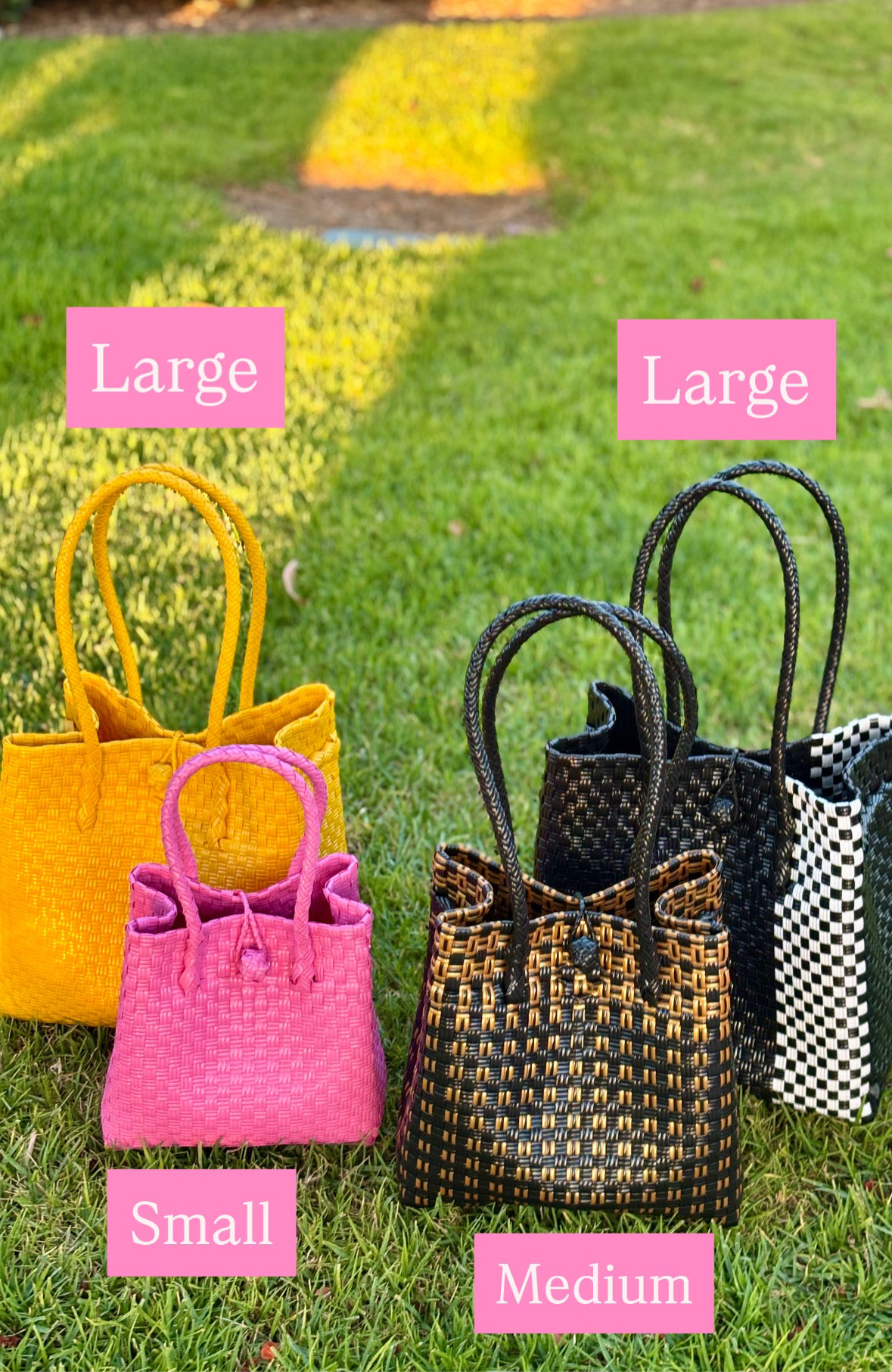 Four handbags of different sizes on grass with labeled sizes.