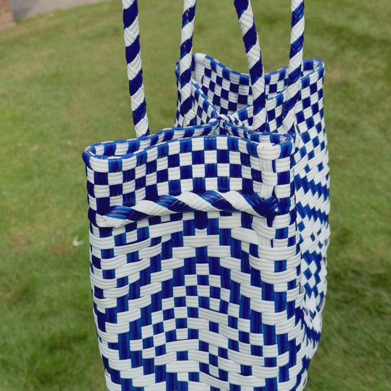 Sustainable recycled plastic tote bag in blue and white pattern on grass.