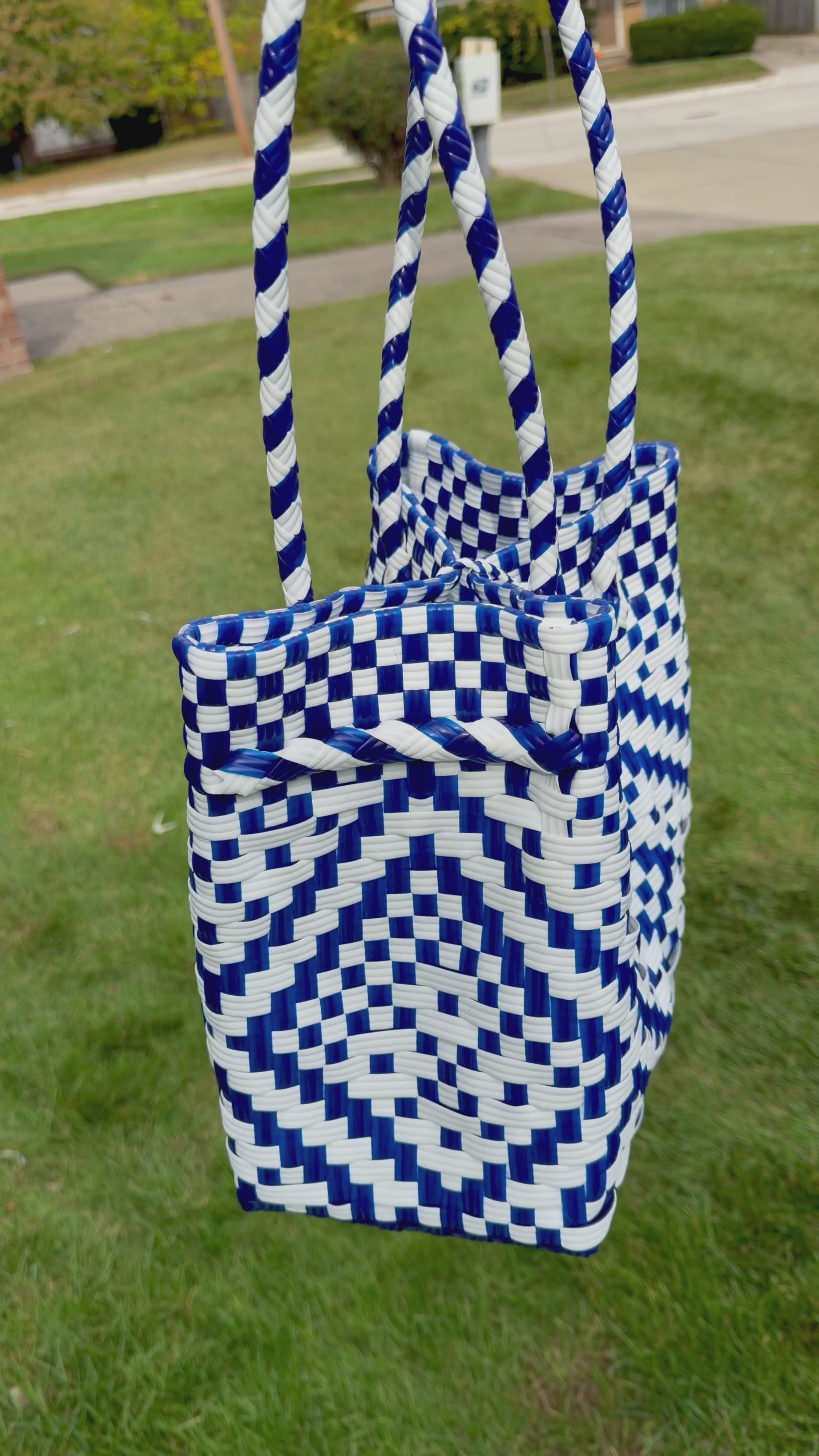 Sustainable recycled plastic tote bag in blue and white pattern on grass.