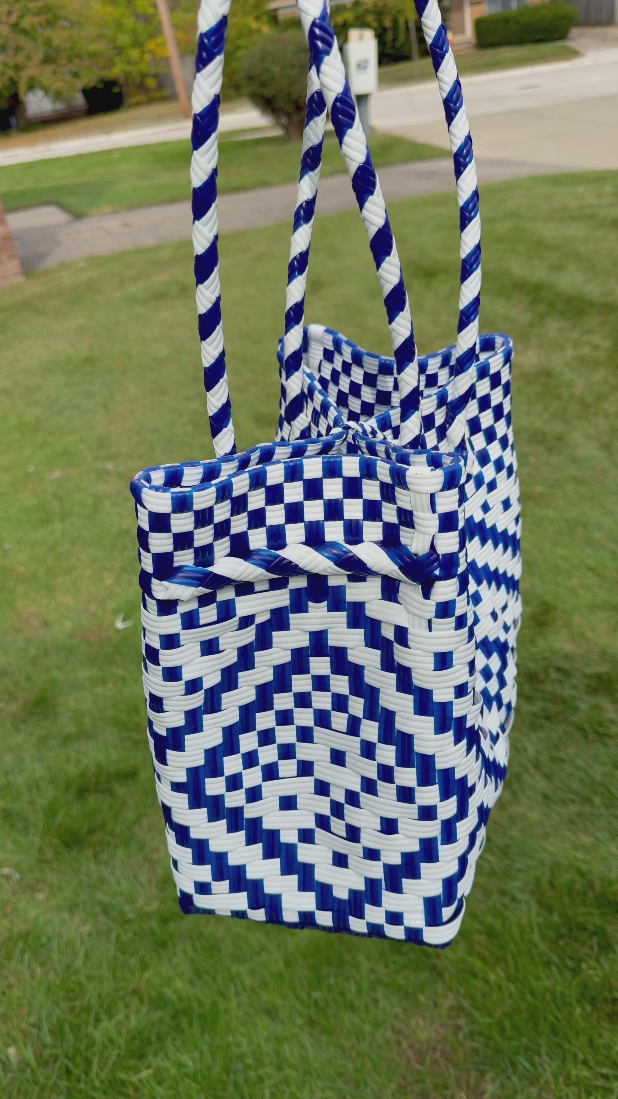 Sustainable recycled plastic tote bag in blue and white pattern on grass.